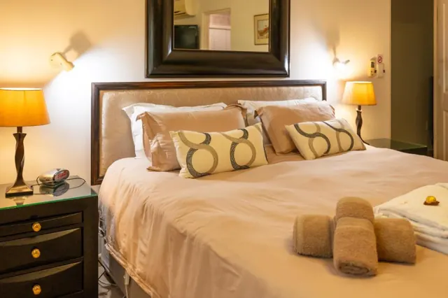 Bed made up with patterned cushions and rolled towels
